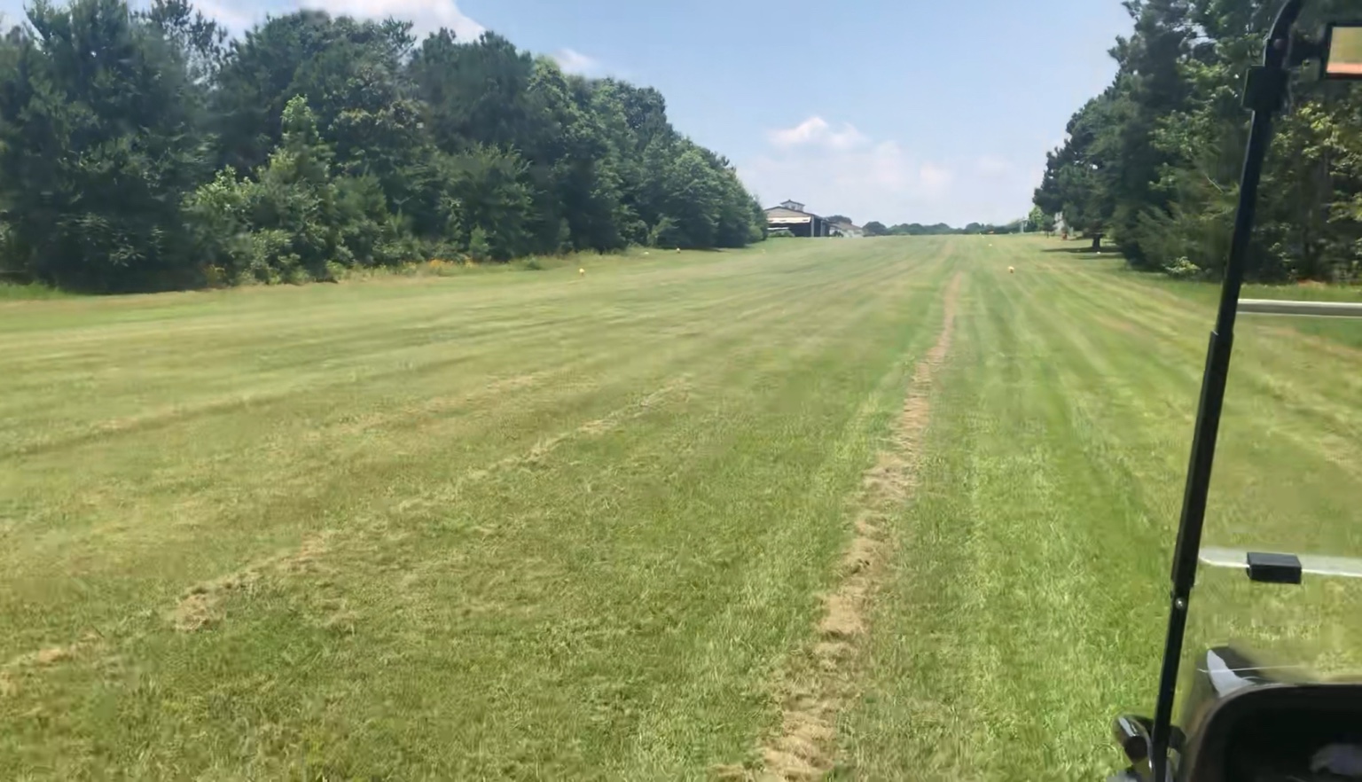 Grass runway and nearby hangar at Aero Estates Airpark