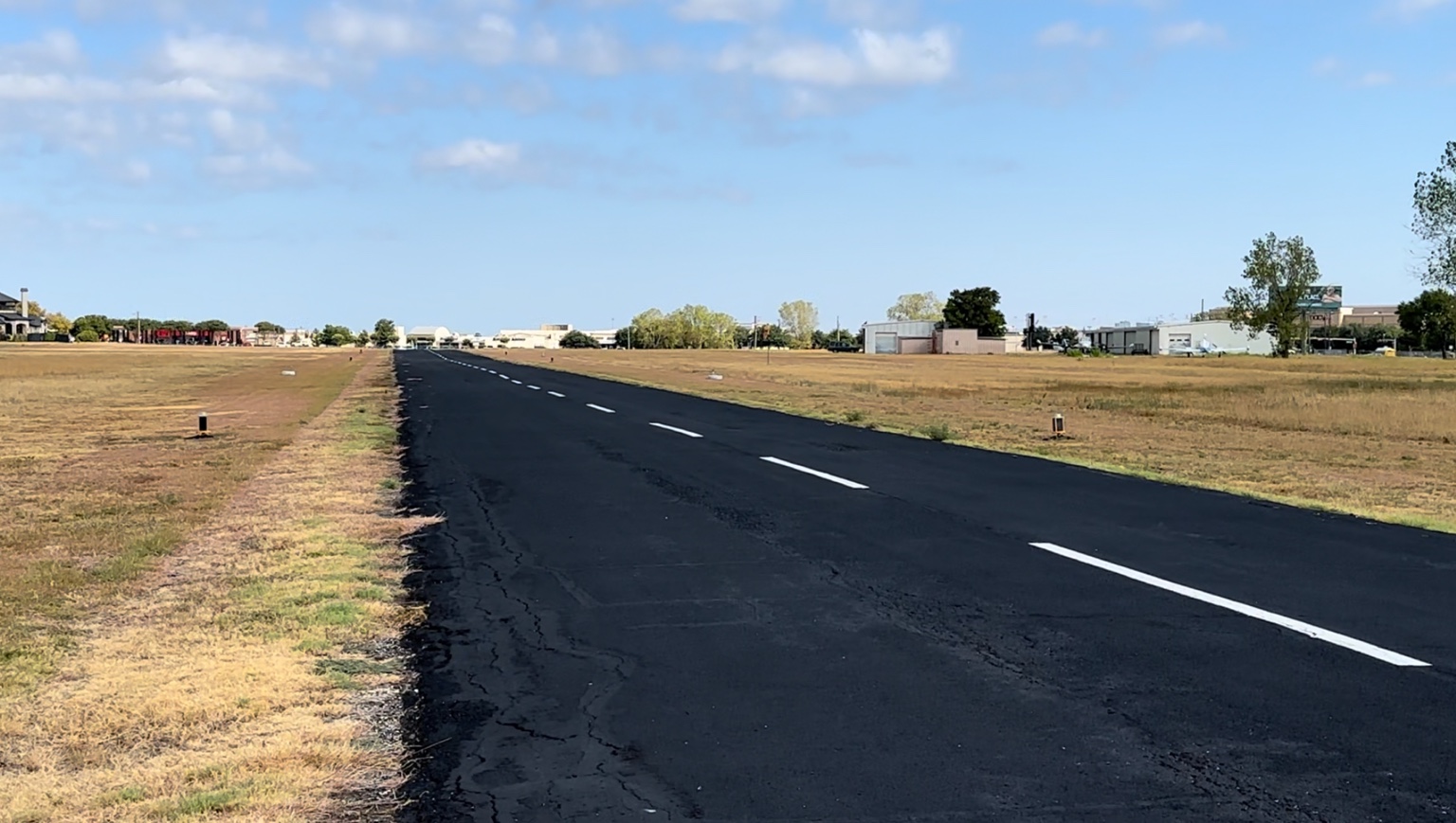 Ground-level view along the asphalt runway at Air Park Dallas