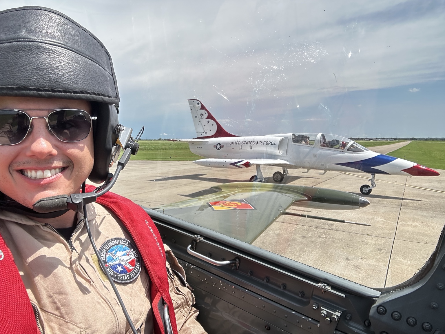John Naugle in the cockpit with a jet on the ramp
