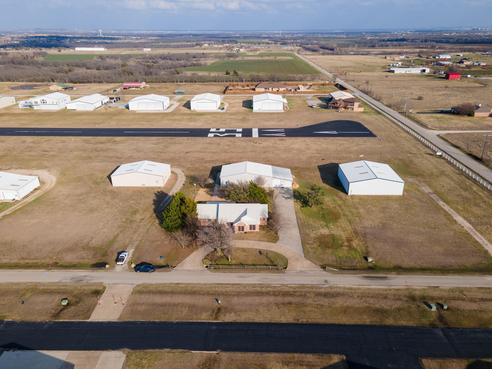 Aerial view of Runway 17 at Propwash Airport with hangars and homes