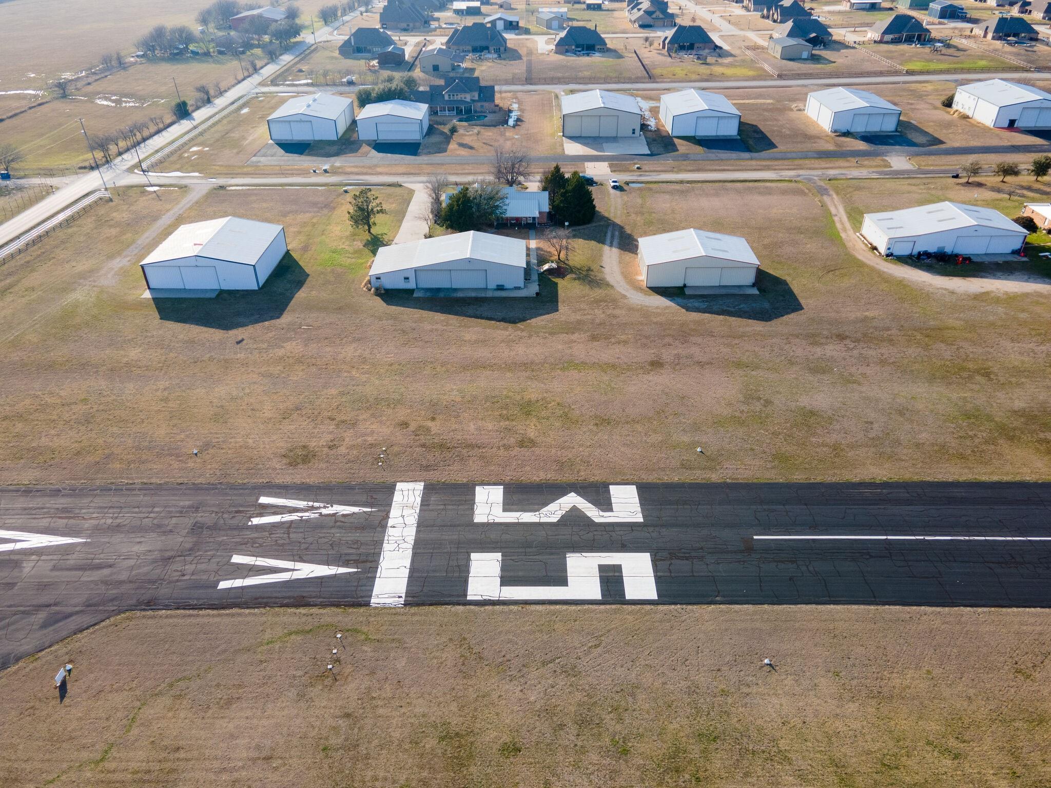 Aircraft hangars and taxi access beside Runway 17/35 at Propwash Airport