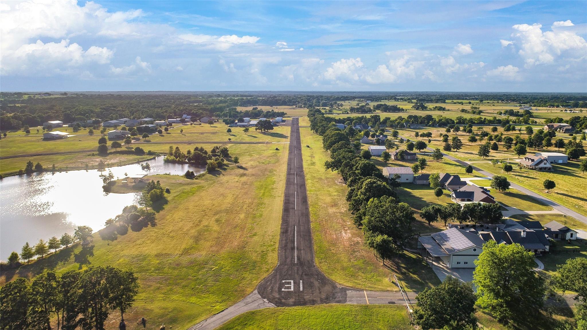 Aerial view of a Texas airpark runway, taxiways, hangars and homes